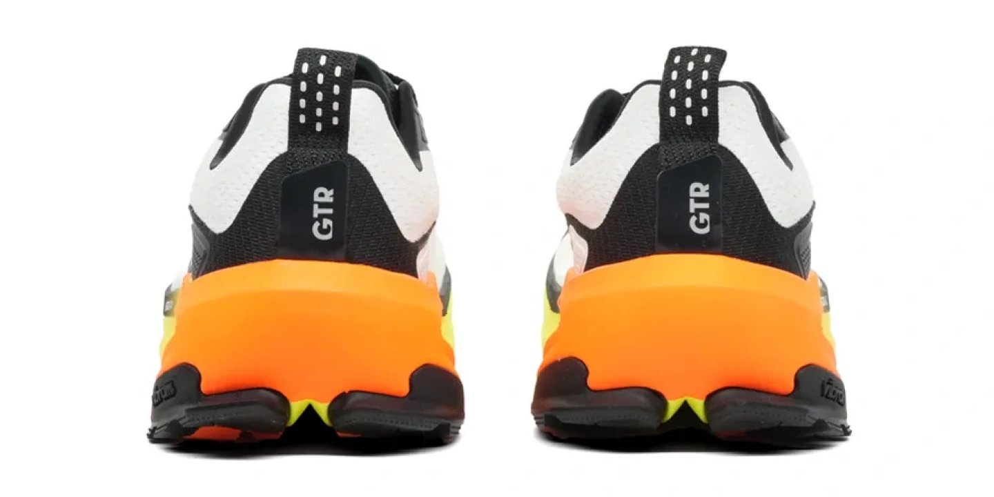 Rear view of the Altra Olympus 7 trail running shoes in black and white with a vibrant orange midsole and GTR heel label.