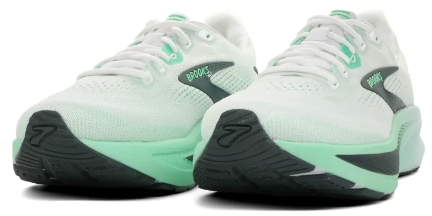 Brooks Ghost 18 running shoes in white and mint green, showing the cushioned midsole and knit upper from a rear three-quarter angle.