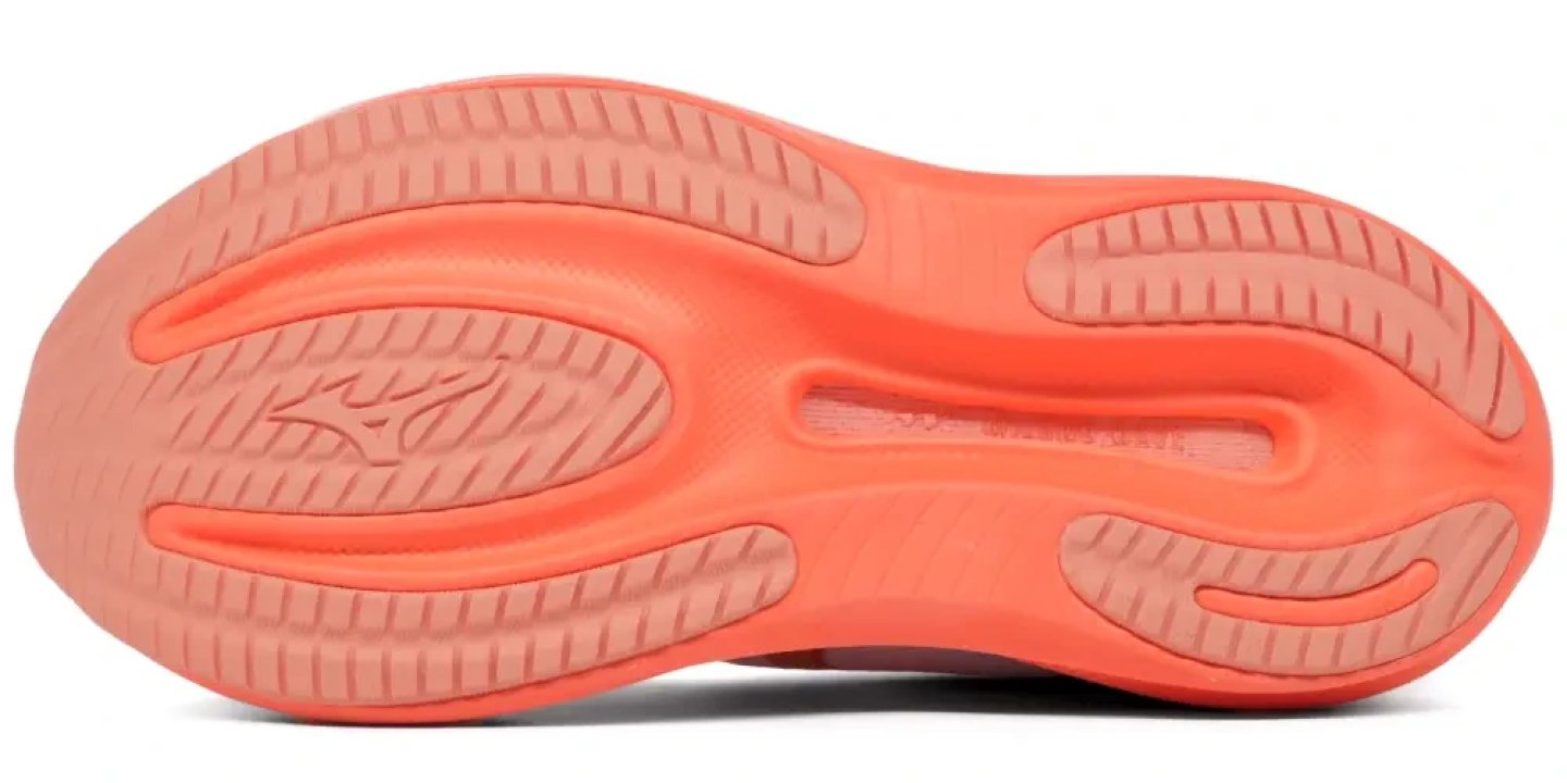 Bottom view of the Mizuno Wave Rider 30 running shoe outsole in coral orange, showing traction zones and Wave plate channels.