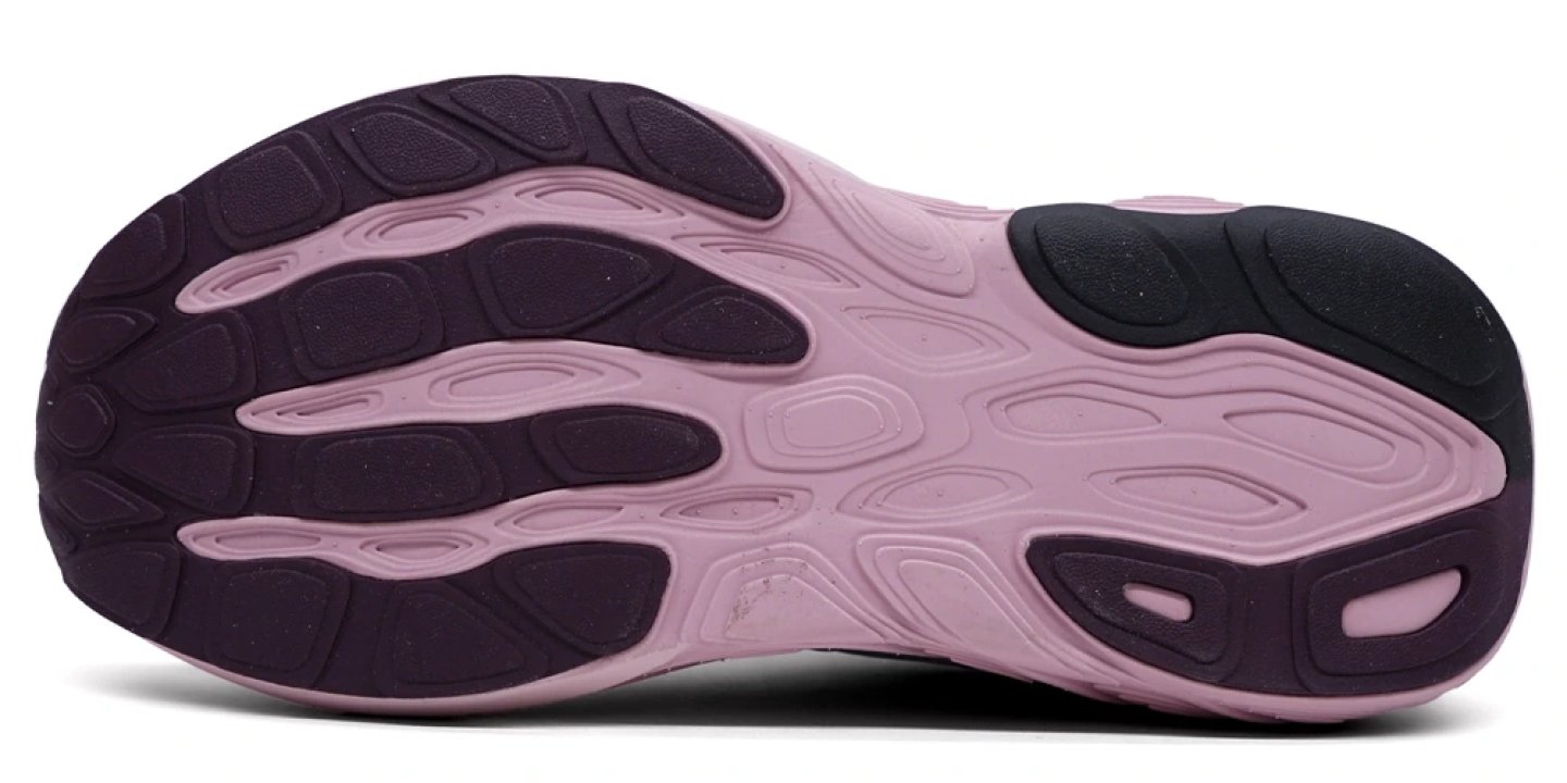 Bottom view of New Balance 880v15 running shoe outsole showing segmented purple rubber crash pads and pink foam base