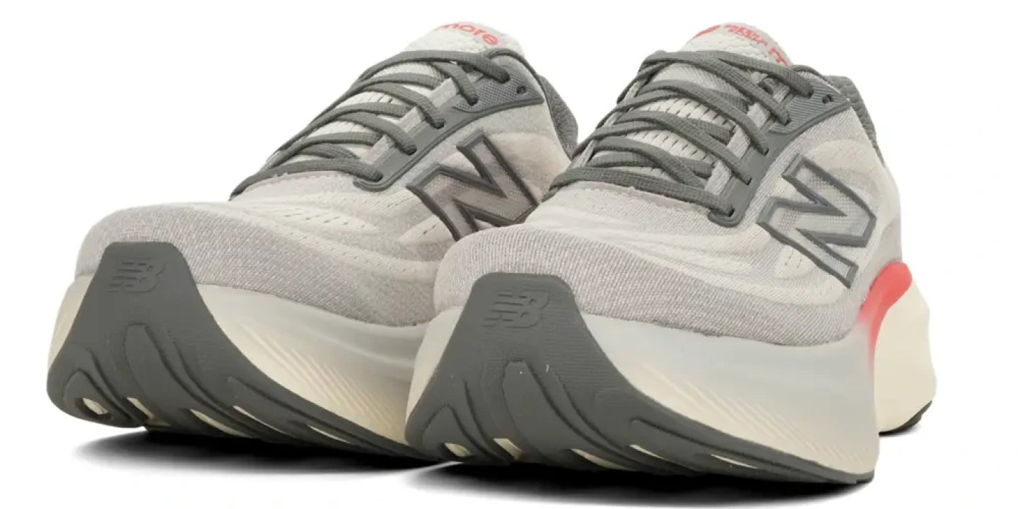 New Balance More V6 running shoes in grey with coral heel accent, shown as a pair from the rear angle on white background.