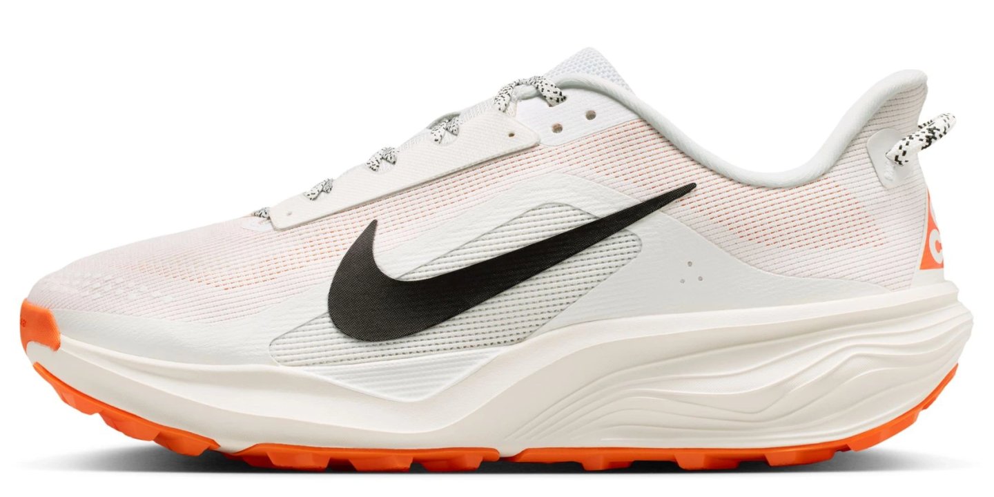 Nike ACG Pegasus Trail running shoe in white with black Swoosh and vibrant orange lugged outsole, lateral view on white background.