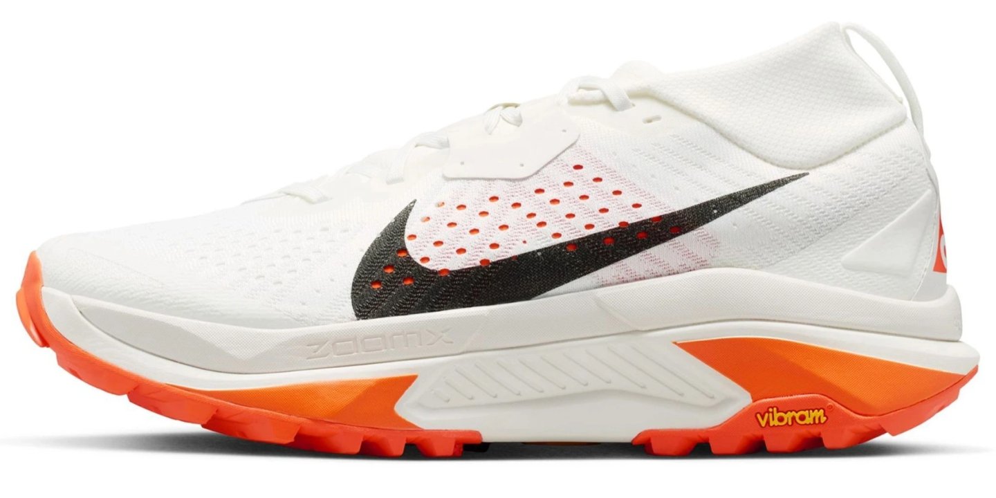 Nike ACG Zegama trail running shoe in white with black Swoosh and bright orange Vibram outsole, lateral view
