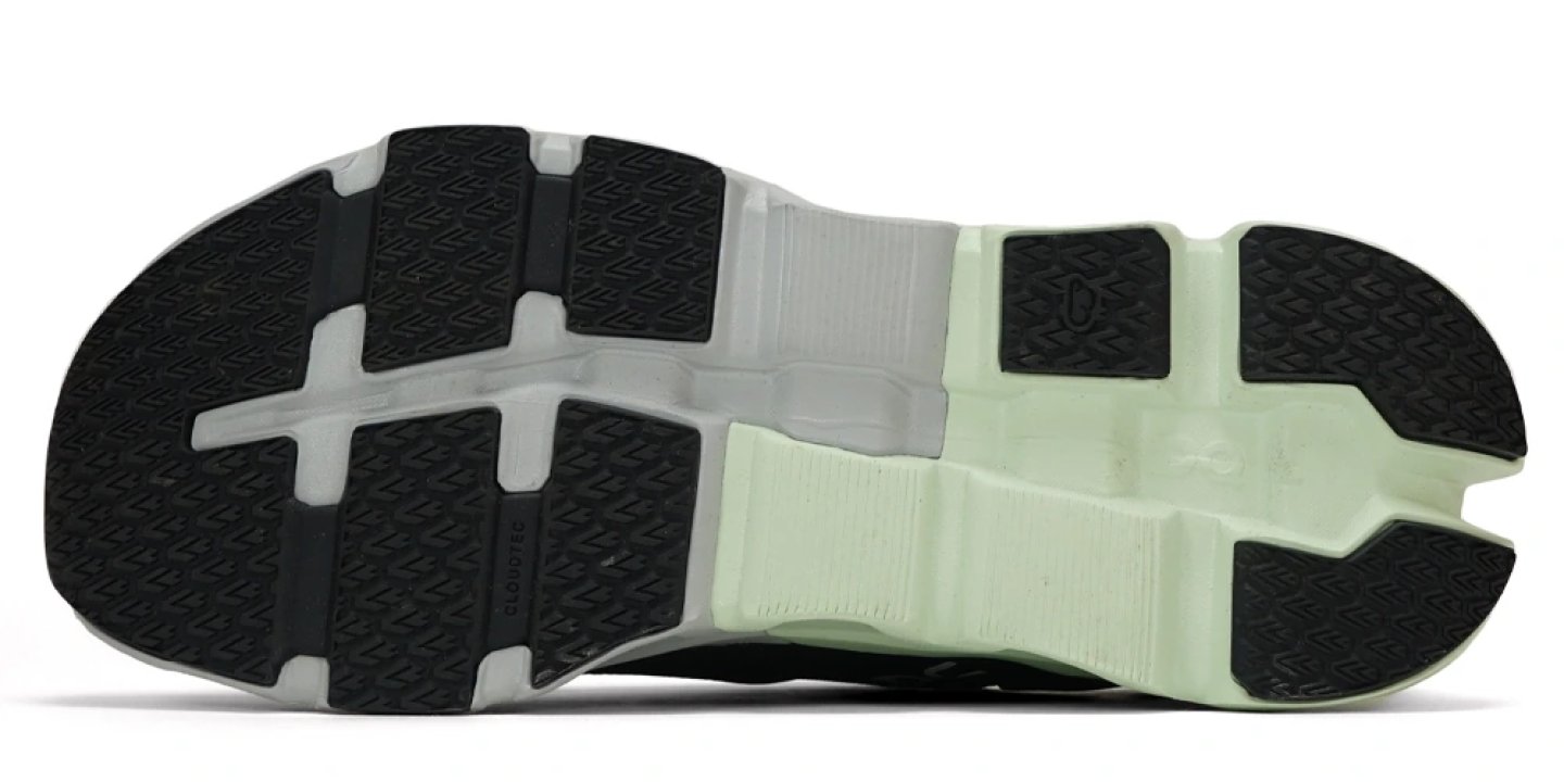Bottom view of the On Cloudflyer 5 running shoe outsole showing black rubber traction pods, CloudTec® zones and mint midsole.