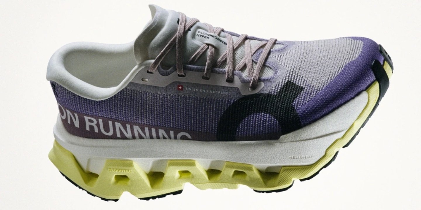 On Cloudmonster Hyper running shoe in purple and yellow colourway, featuring Helion HF midsole and CloudTec outsole, side profile view.