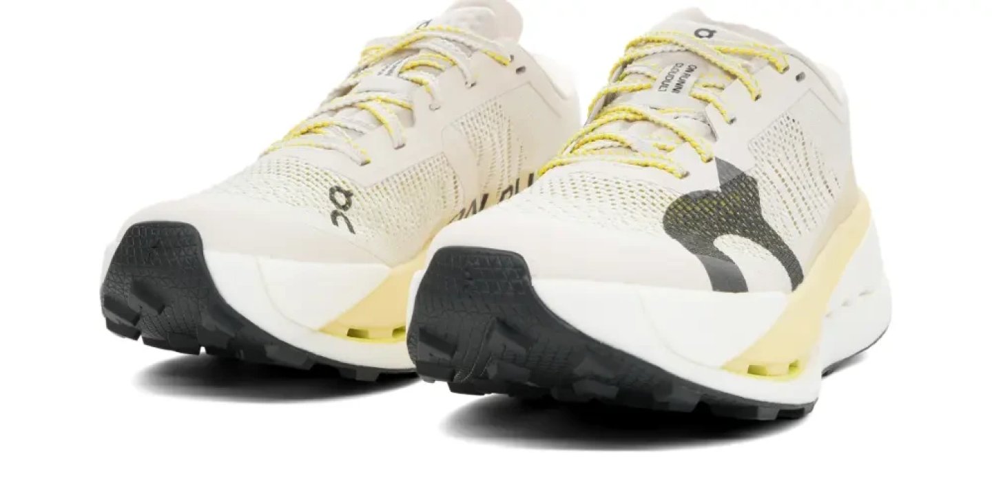 On Cloudultra Pro trail running shoes in cream and yellow with black lugged outsole, shown as a pair on white background