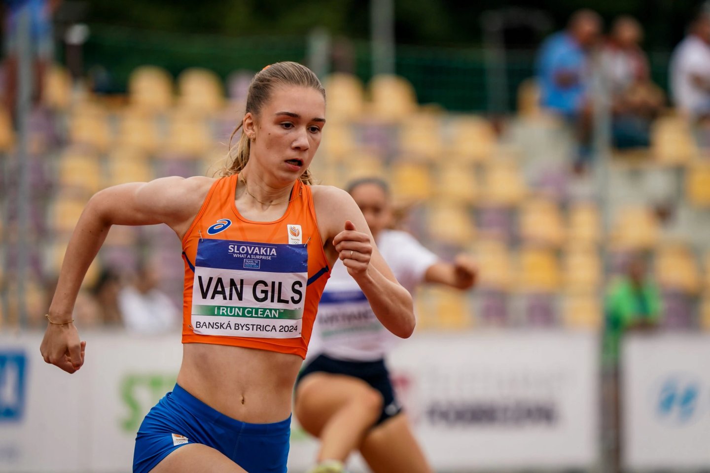 Athlete Van Gils in orange ASICS Netherlands singlet sprinting during 400m Hurdles Women semi-final, Banská Bystrica 2024