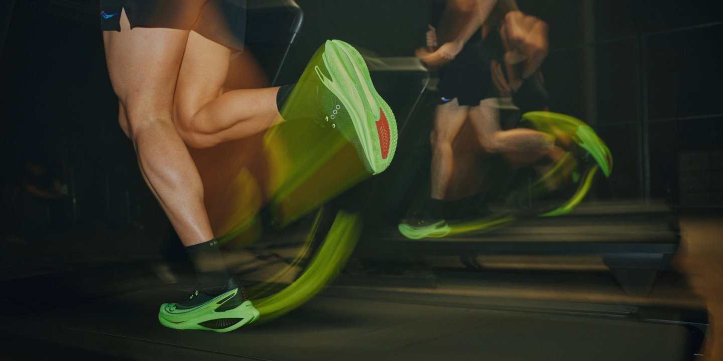 Close-up of runner wearing neon green racing shoes on a treadmill, motion blur emphasising high-speed stride
