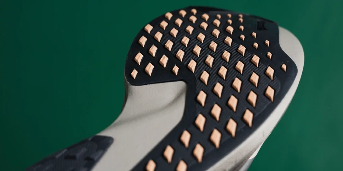 Adidas Adizero Evo SL ATR outsole showing diamond-shaped rubber lugs in tan on a dark rubber base with white midsole