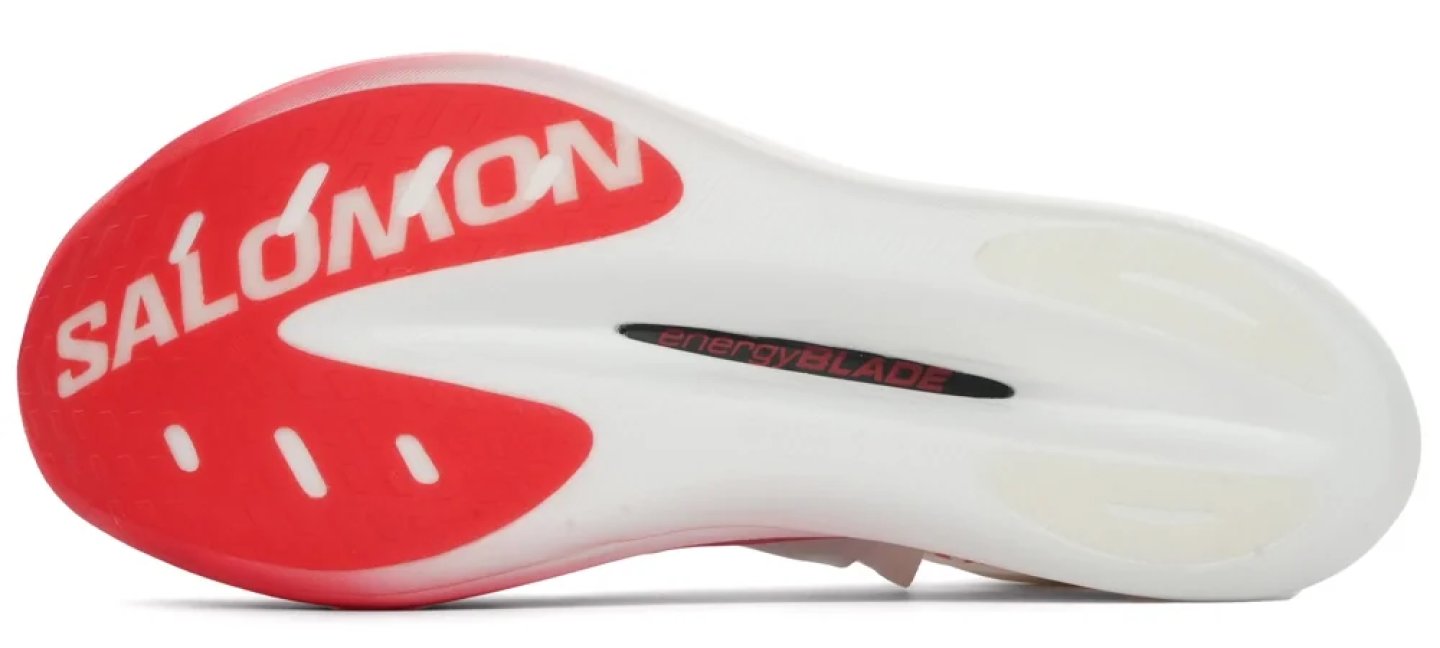 Bottom view of Salomon running shoe outsole with red heel rubber, white EnergyBlade midsole, and Salomon branding.