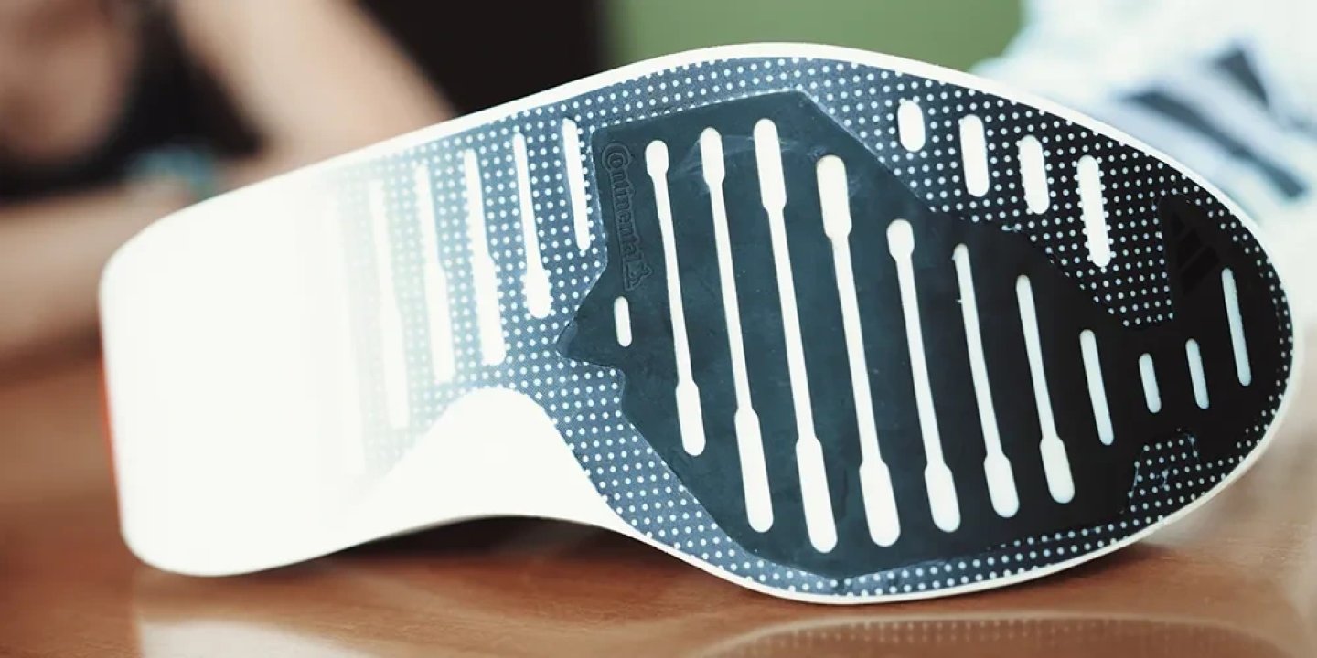 Bottom view of Adidas Adizero Prime EVO X shoe showing Continental rubber outsole with flex grooves and dot traction pattern
