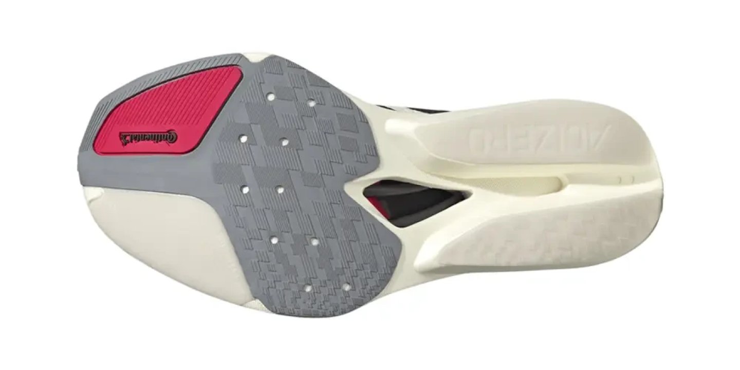 Bottom view of Adidas Adizero 3 running shoe outsole showing grey and pink Continental rubber grip zones on cream midsole