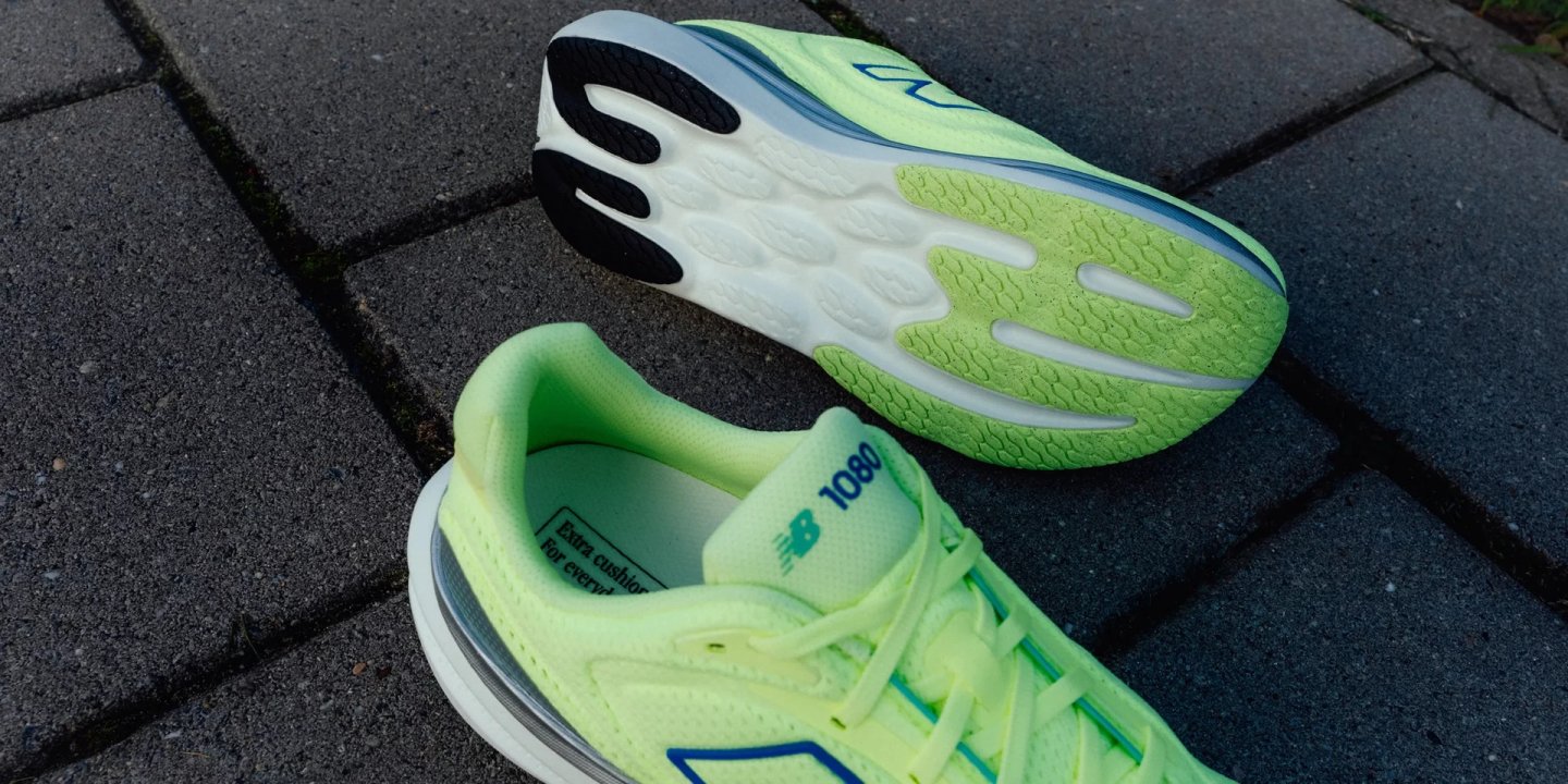 New Balance 1080v15 running shoe in Lime Glow, showing top and sole views on grey paving stones