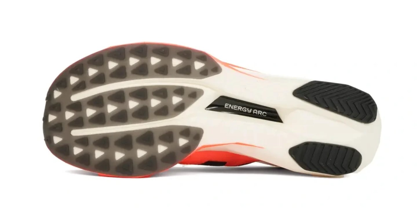 Outsole of the New Balance FuelCell SuperComp Elite v5 showing Energy Arc label, triangular lugs and black rubber heel and forefoot zones