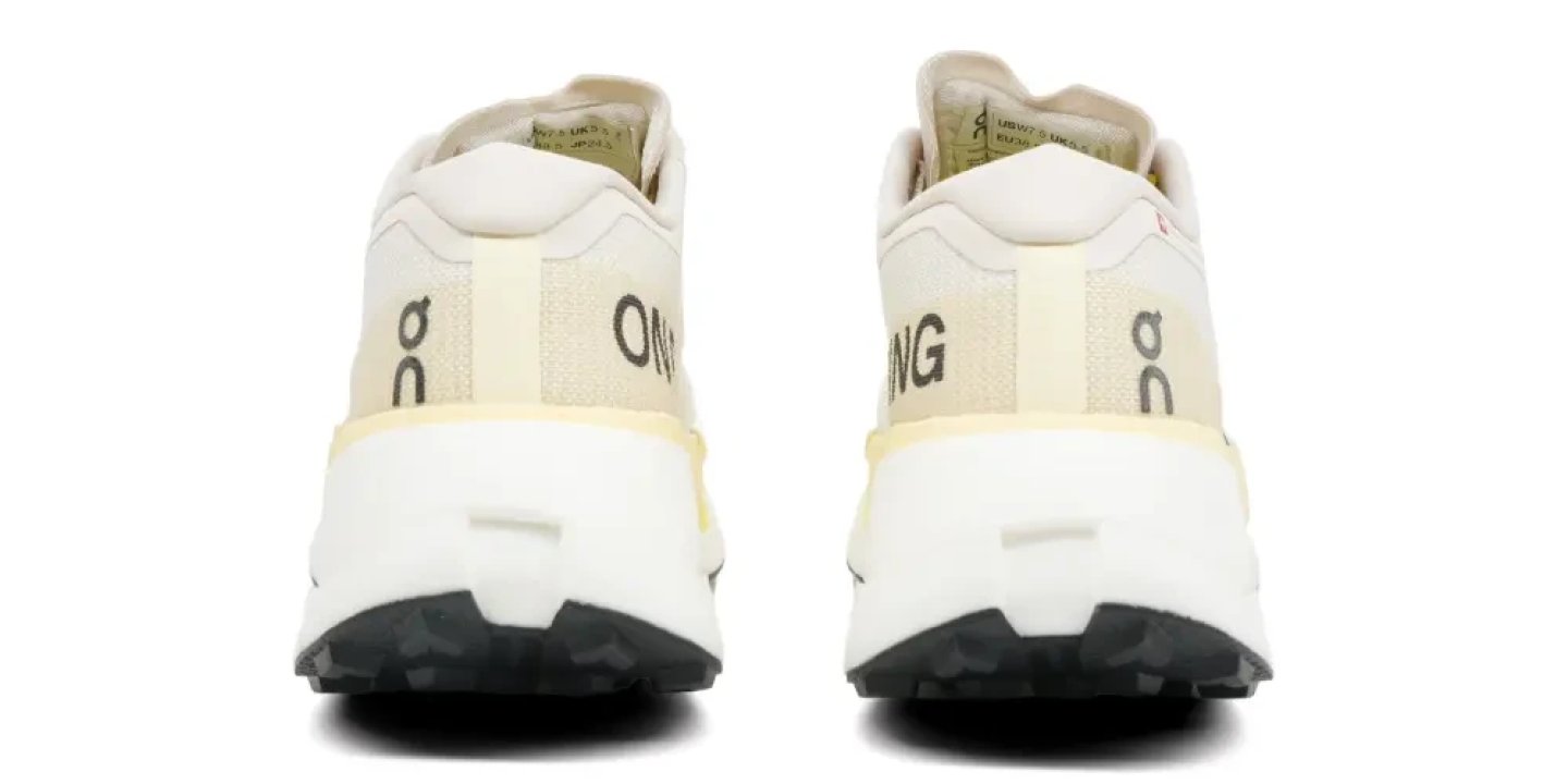 Heel view of the On Cloudultra Pro trail running shoes in off-white, showing the logo, cushioned collar and rugged black outsole.