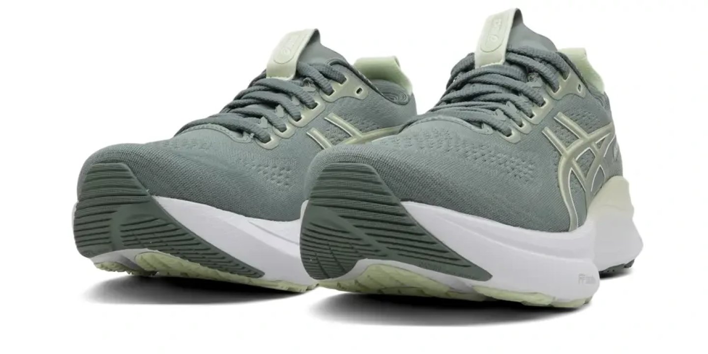 Pair of ASICS Gel-Kayano 32 running shoes in sage green with white midsole, shown from rear three-quarter angle