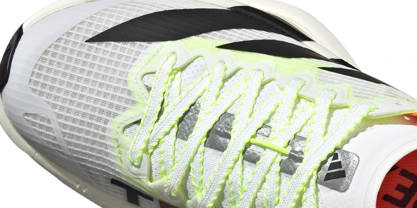 Close-up top view of Adidas Adizero Adios Pro running shoe in white with neon lime green and black accents