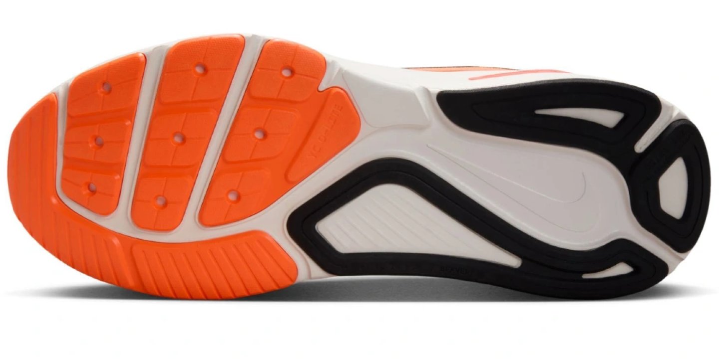 Bottom view of the Nike Structure 26 running shoe outsole showing orange rubber traction pods and white midsole with Swoosh logo