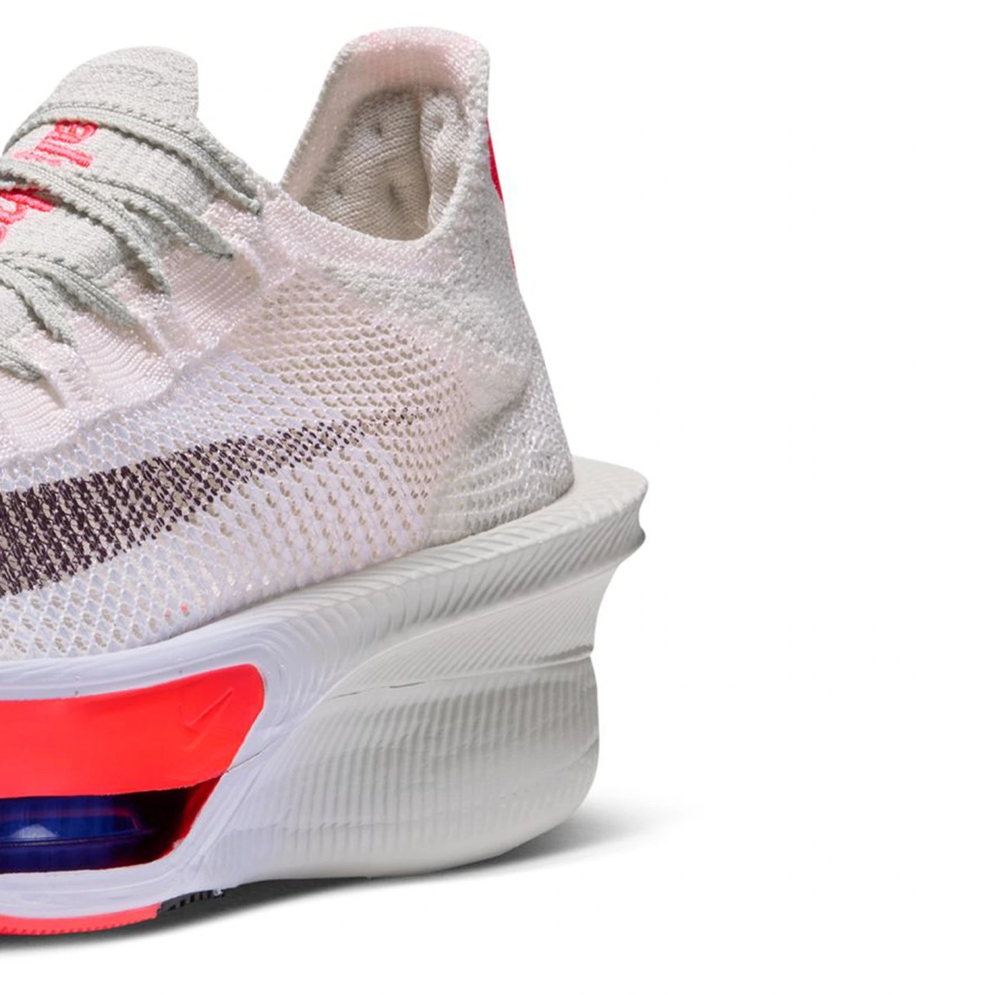 Nike Alphafly 4 heel detail showing white Flyknit upper, thick ZoomX foam midsole, and red-blue Air Zoom unit at the rear.