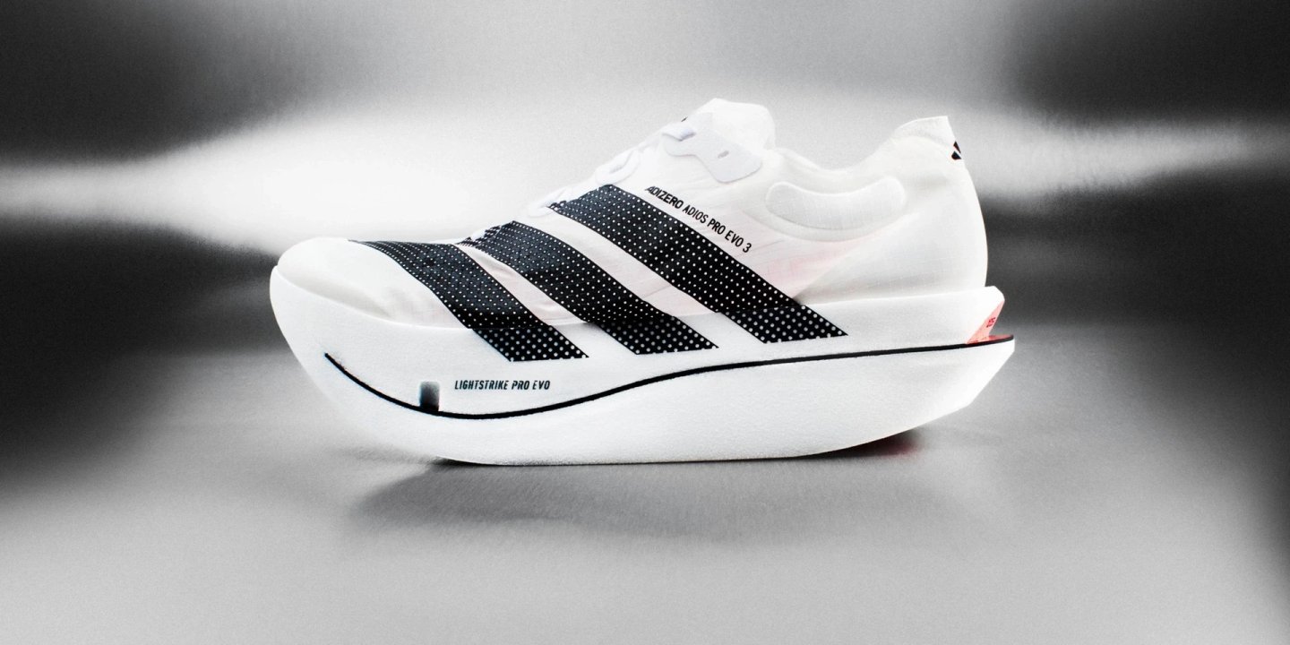Adidas Adizero Adios Pro Evo 3 racing shoe in white with black three stripes and Lightstrike Pro Evo midsole, side profile view.