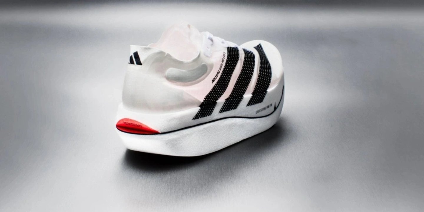 Rear three-quarter view of the Adidas Adizero Adios Pro Evo 3 in white with black stripes and red heel accent