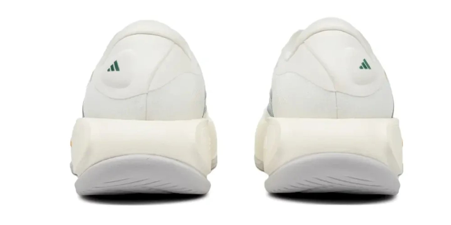 Rear view of two Adidas Supernova Prima 3 running shoes in white with green Adidas logo on heel collar