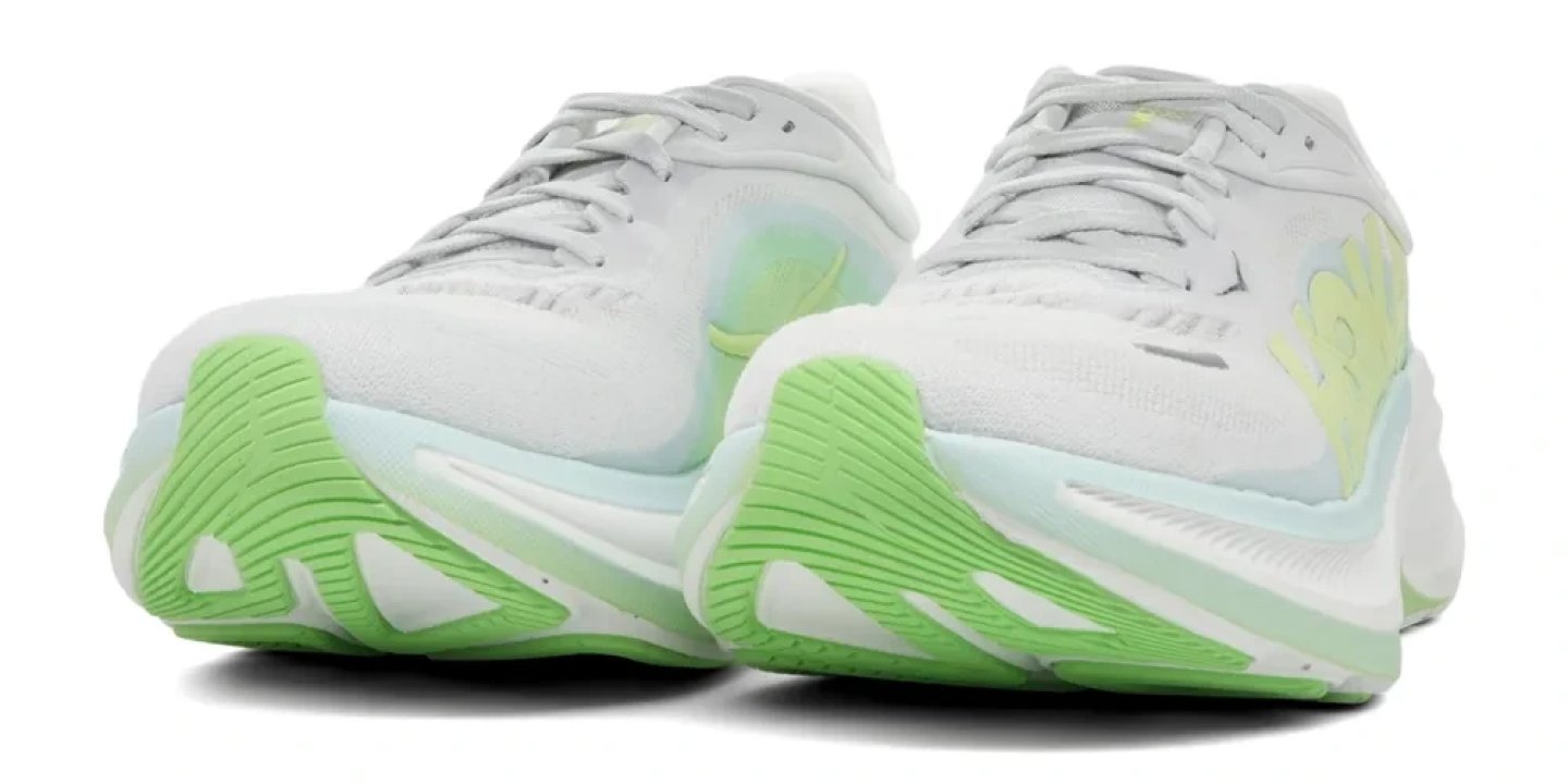 Rear view of Hoka Clifton Pro running shoes in white and light green with a thick, ribbed green outsole