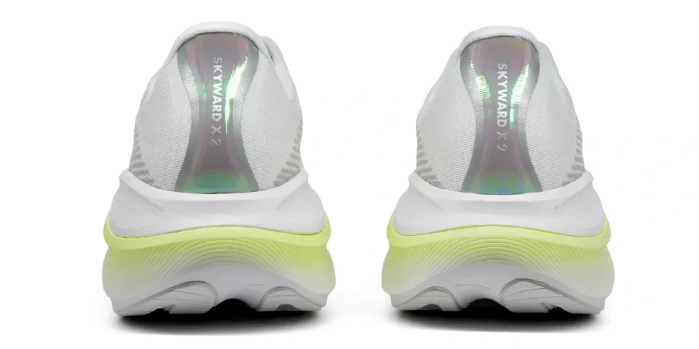 Hoka Skyward X 2 running shoes seen from the back, featuring a white upper, iridescent heel lining, and lime green midsole.