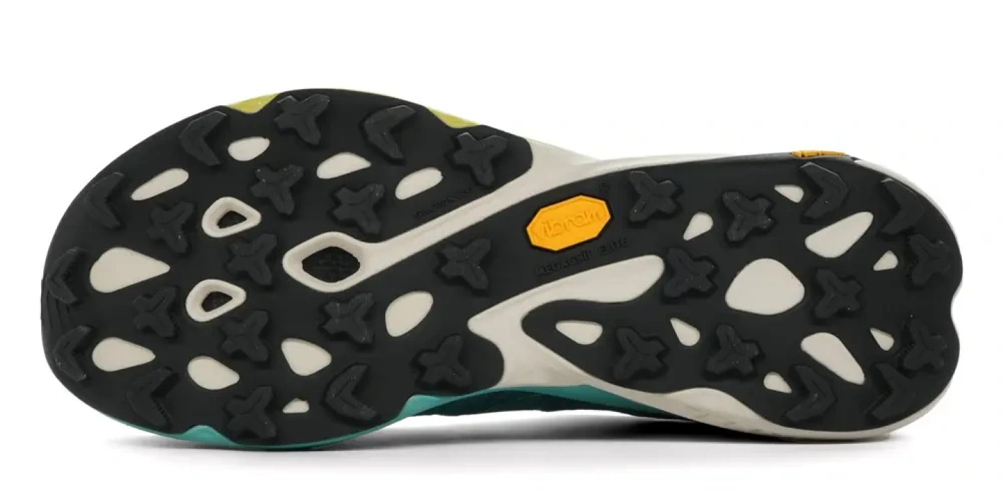 Bottom view of Merrell SpeedArc Peak trail running shoe showing black multi-directional lug outsole with cream midsole panels