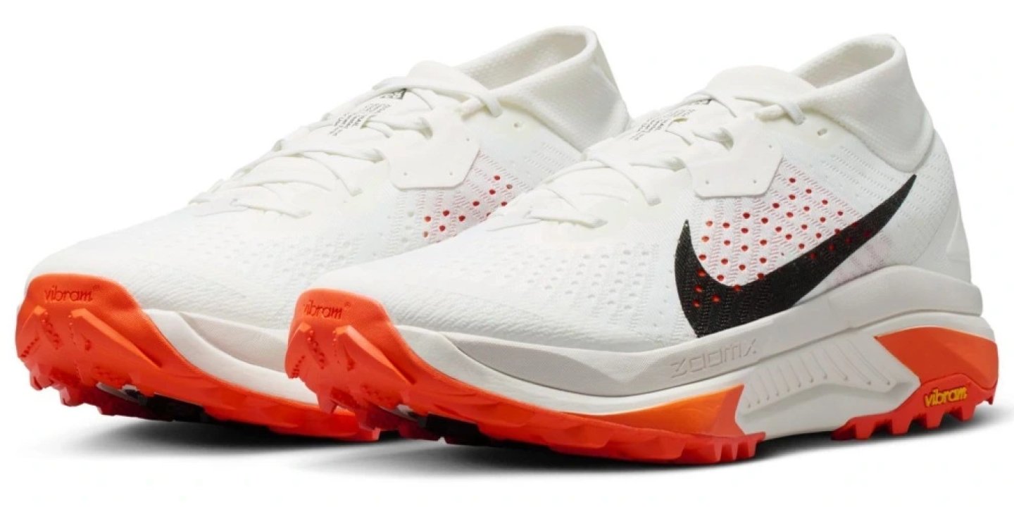 Nike ACG Zegama trail running shoes front in white with black Swoosh and bright orange Vibram lugged outsole