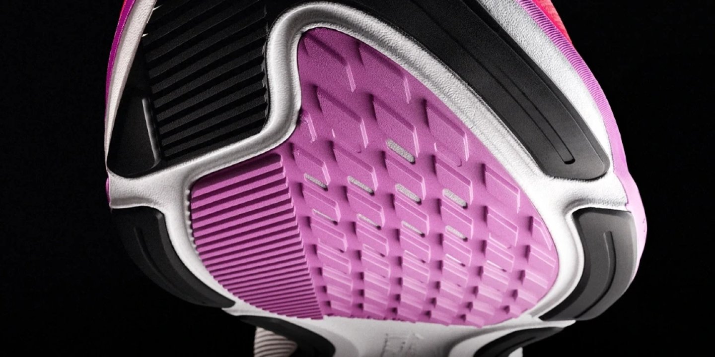 Bottom view of the Nike Pegasus 42 Zoom outsole featuring pink multi-directional rubber lugs and black heel crash pad