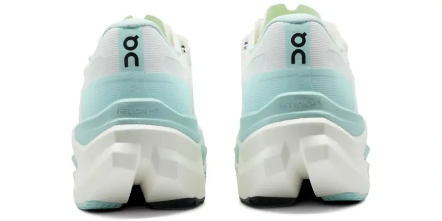 Rear view of On Cloudmonster Hyper running shoes in mint and white, showing Helion HF midsole and CloudTec outsole pods
