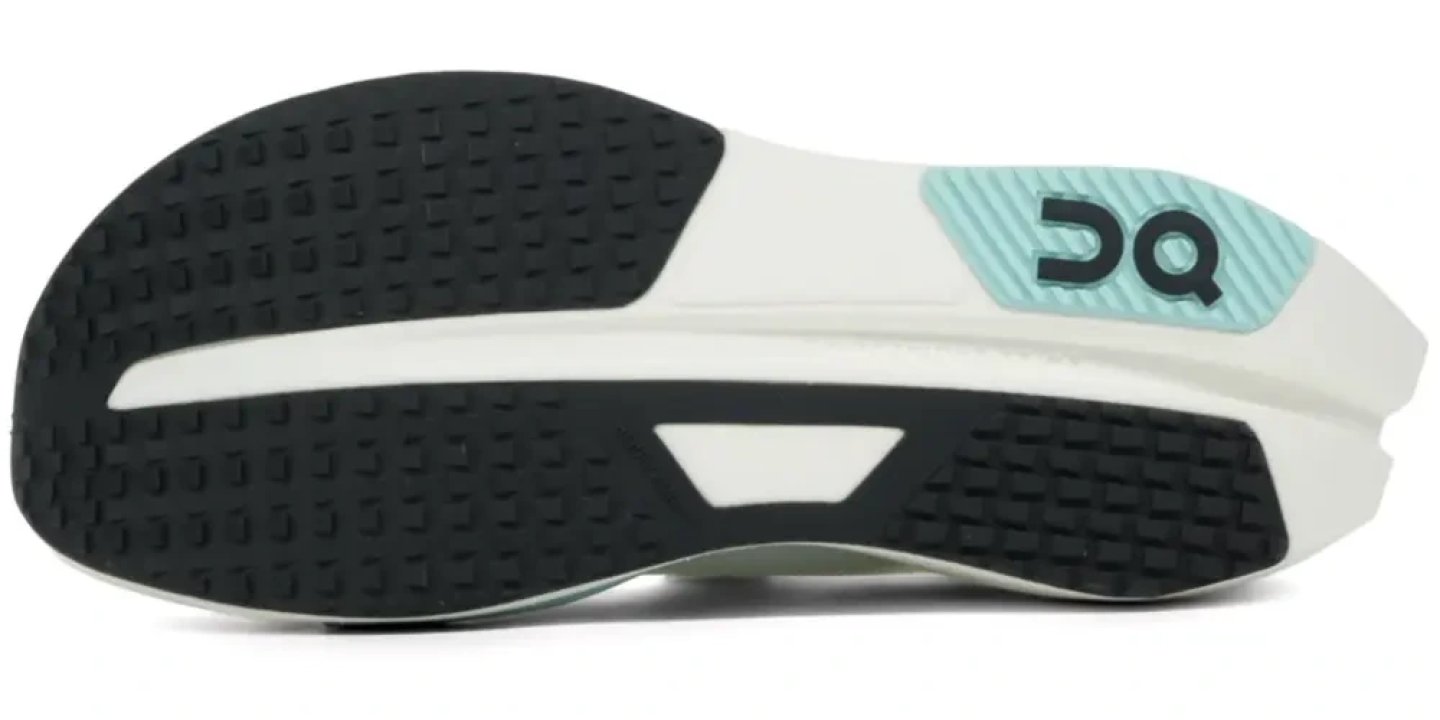 Bottom view of the On Cloud X Tempo Pro running shoe outsole with black rubber traction pods and mint heel accent