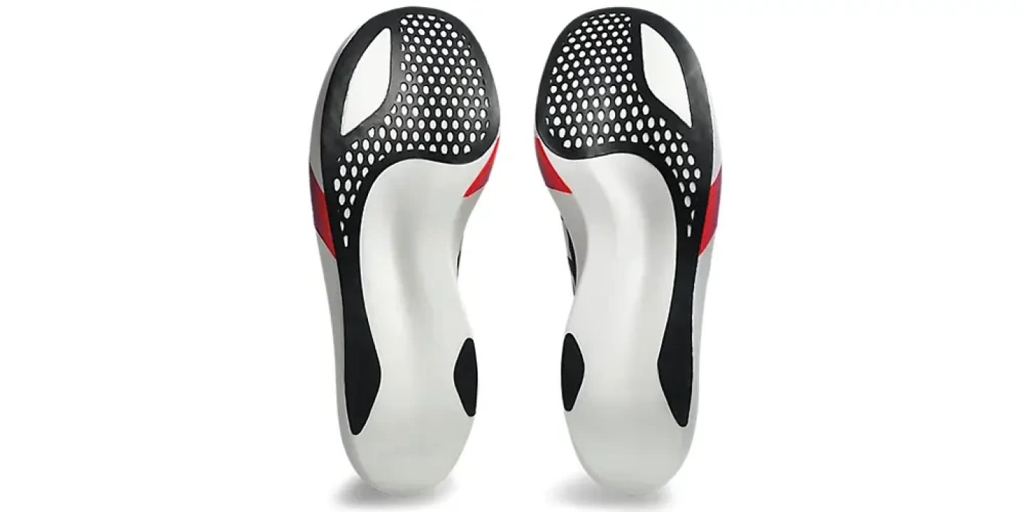 Pair of white, black and red running shoe insoles with perforated forefoot panel and contoured arch support, top-down view