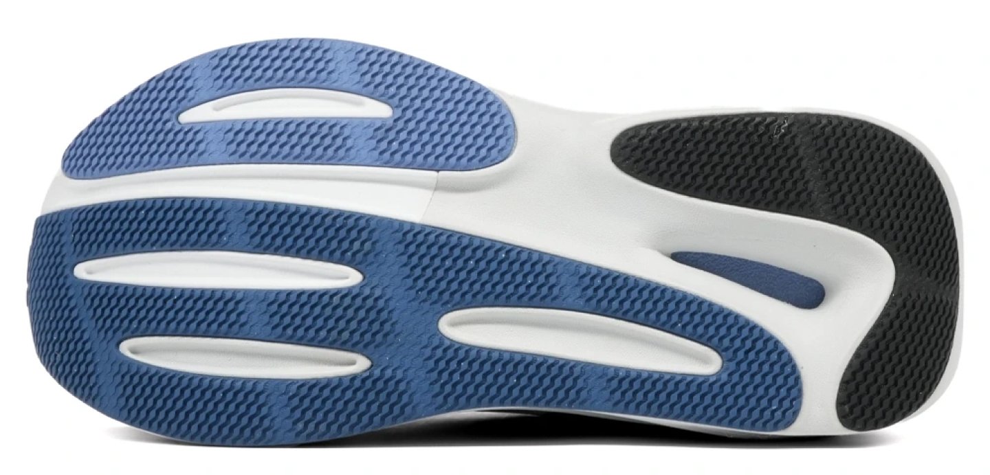 Bottom view of the New Balance 860v15 running shoe outsole showing blue rubber traction pods and white midsole flex grooves.