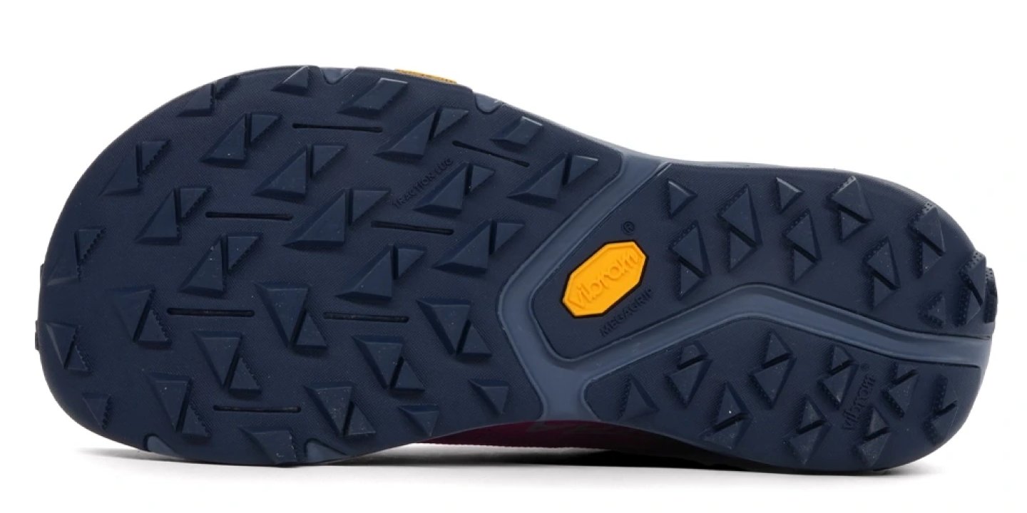 Bottom view of the Altra Experience Wild 3 trail running shoe outsole with navy Vibram MegaGrip lugs and gold Vibram logo badge