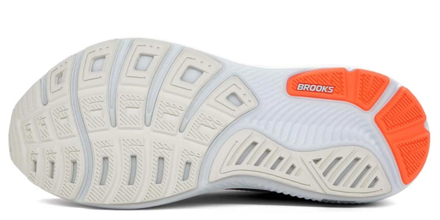 Bottom view of Brooks Ghost 17 running shoe outsole showing white rubber traction pattern with orange heel pod