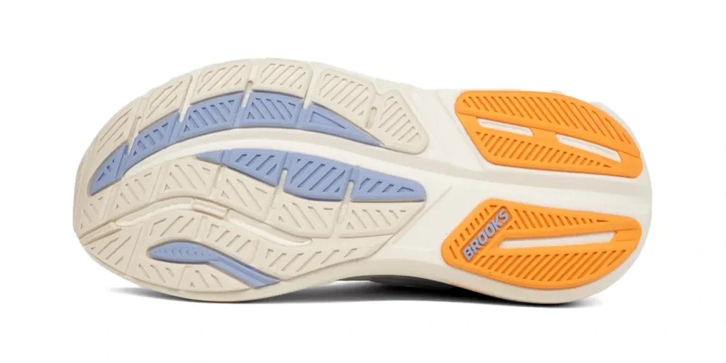 Brooks Ghost Max 3 running shoe outsole showing cream foam base, blue flex grooves, and orange rubber traction zones with Brooks logo