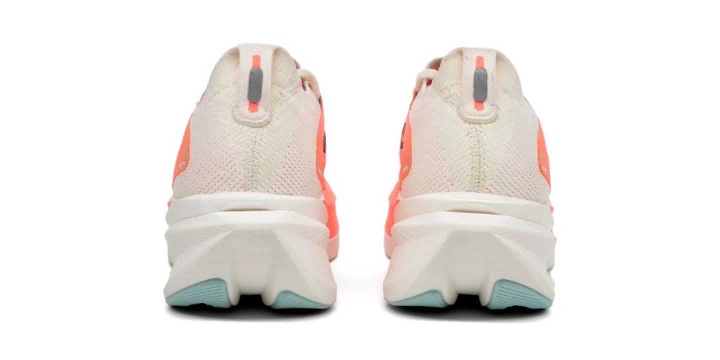 Rear view of Brooks women's running shoes in cream and coral with white midsole and teal rubber outsole lugs