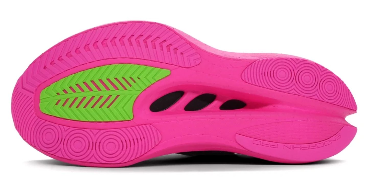 Bottom view of Saucony Endorphin Pro running shoe outsole in pink with green rubber traction patch and circular grip pods.