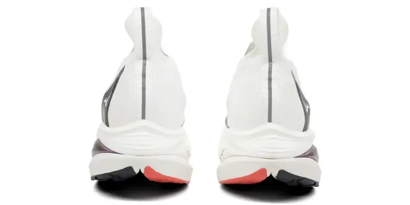 Rear view of two Mizuno white running shoes with coral-red outsole accents and thick white foam midsoles.