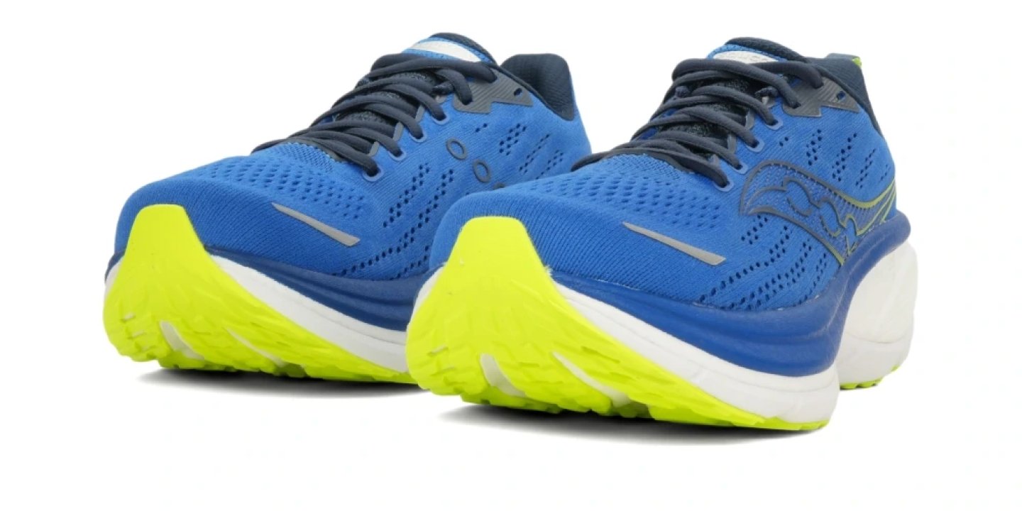 Pair of Saucony Triumph 21 running shoes in blue mesh with navy laces and neon yellow rubber outsole on white background