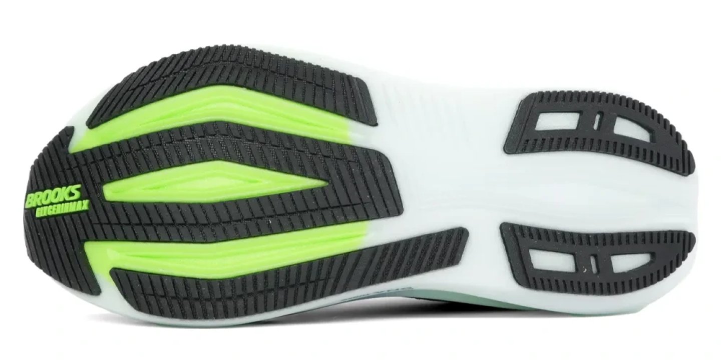 Bottom view of Brooks Glycerin Max running shoe outsole showing black rubber traction lugs, neon green midsole foam and flex grooves