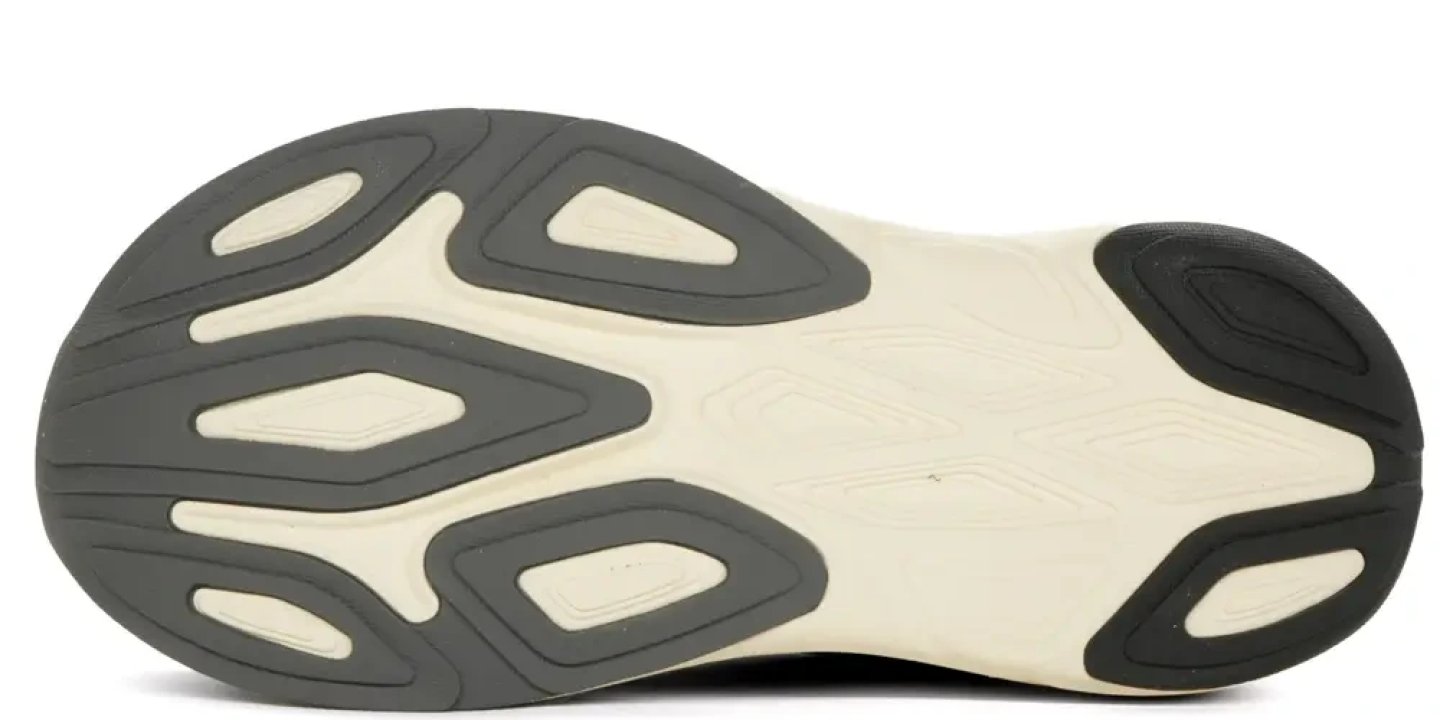 Bottom view of the New Balance More V6 running shoe outsole with grey rubber lugs and cream midsole base.