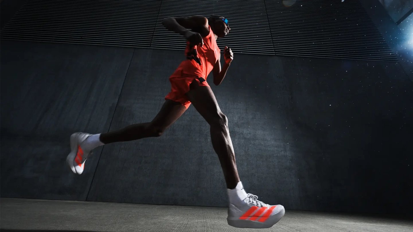 Male runner mid-stride wearing adidas white and orange racing shoes with three-stripe logo and orange running kit