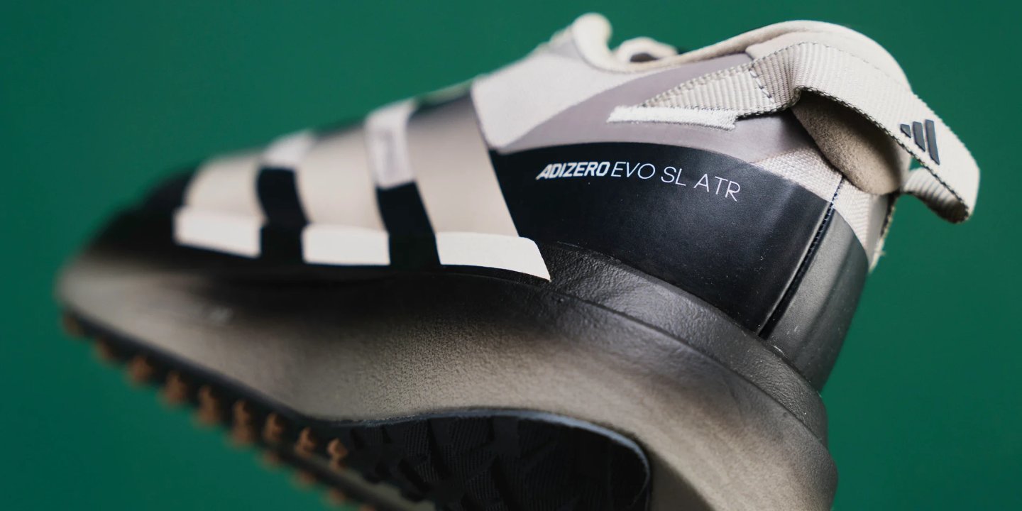 Adidas Adizero Evo SL ATR running shoe heel and midsole close-up showing model name branding and three stripes.