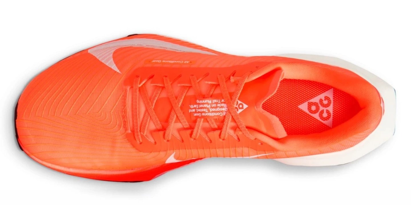 Top view of Nike ACG Ultrafly Trail running shoe in bright orange with cross-lace system and ACG logo on insole